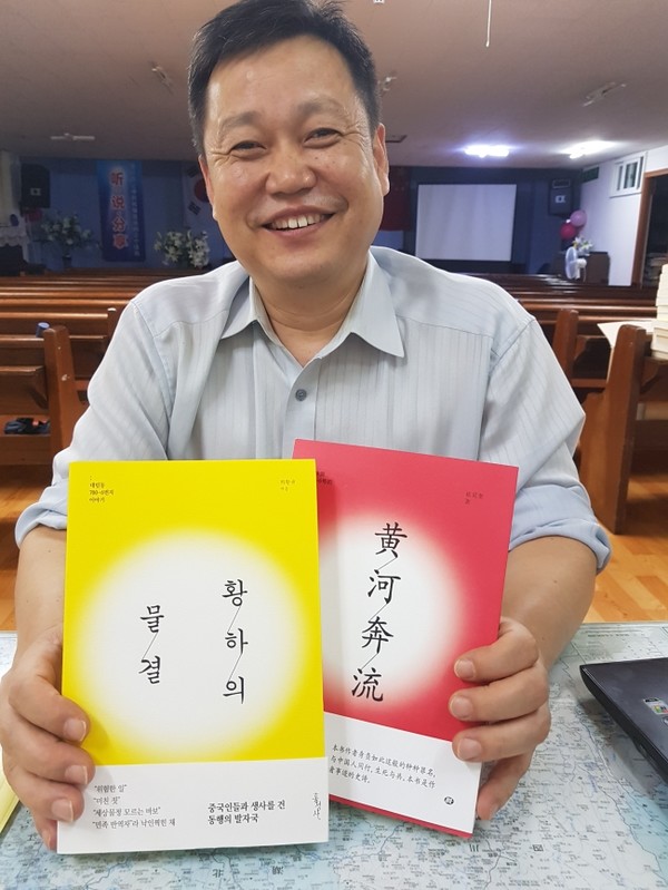 최황규 목사가 <황하의 물결> 한글판과 중국어판을 들고 소개하고 있다