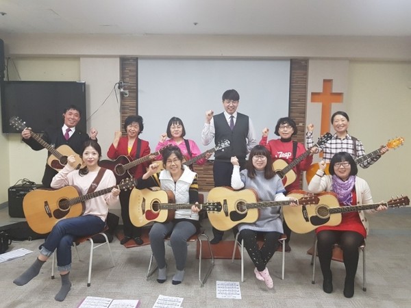 △한중사랑교회 통기타학습반에서 기타를 배우고 있는 동포들